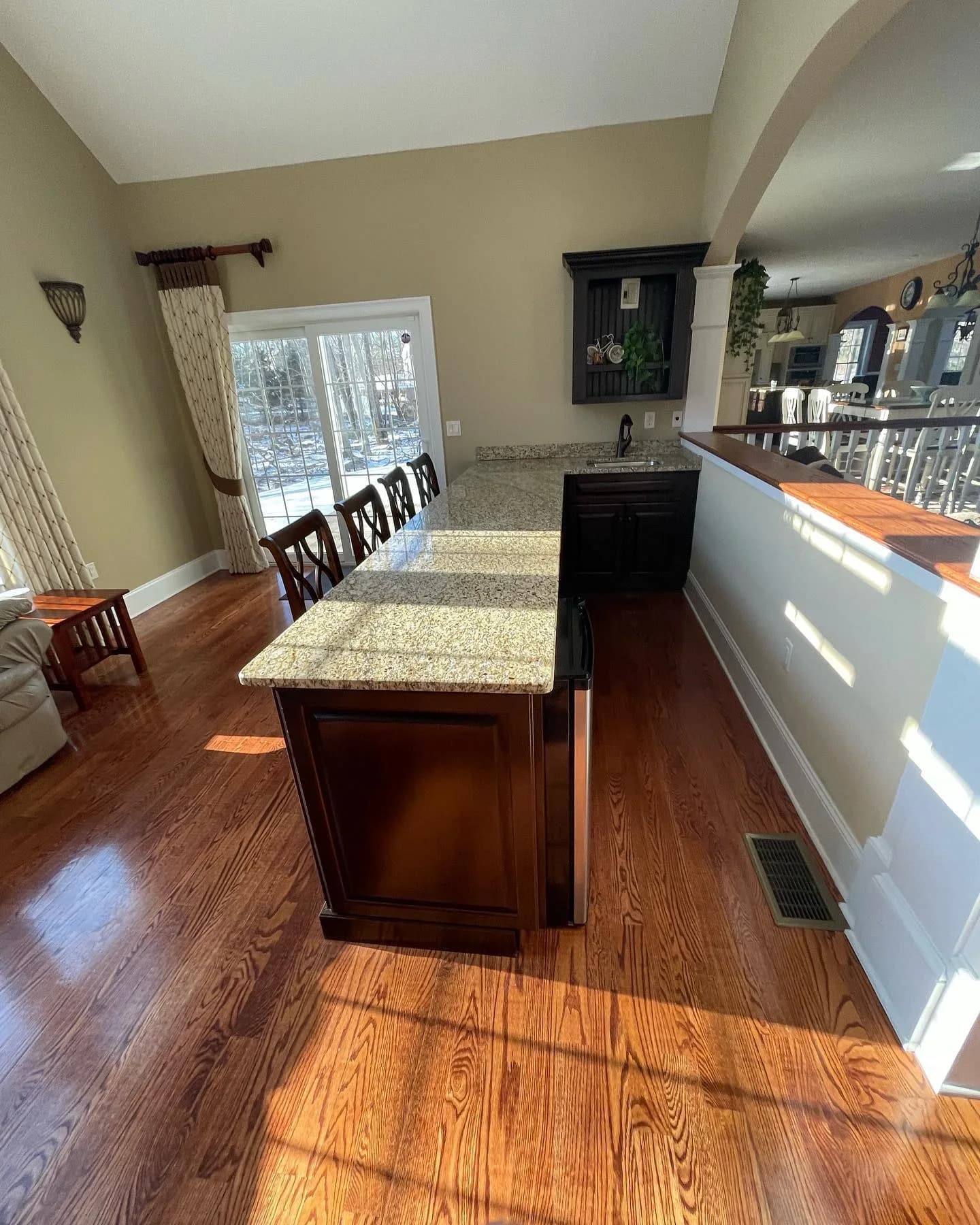 Kitchen remodel detailing dark wood island cabinetry with a granite top.