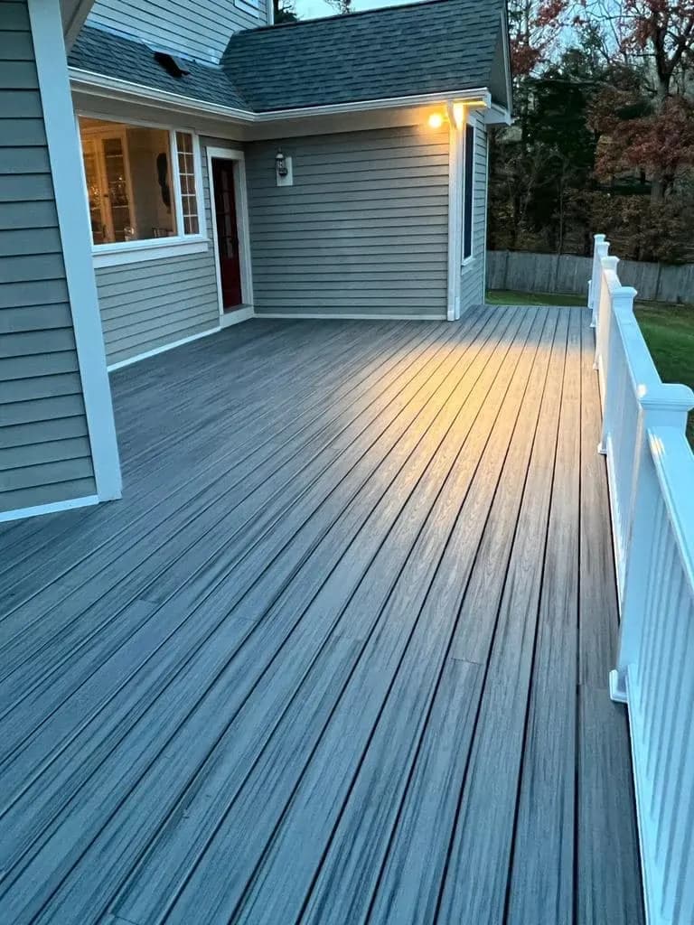 Backyard composite deck showing integrated lighting details at dusk.
